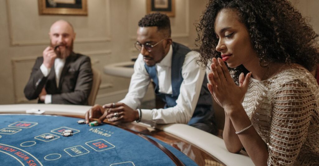 Como funcionam as apostas esportivas online no Brasil Três pessoas jogando em uma mesa de cassino, com expressões concentradas.